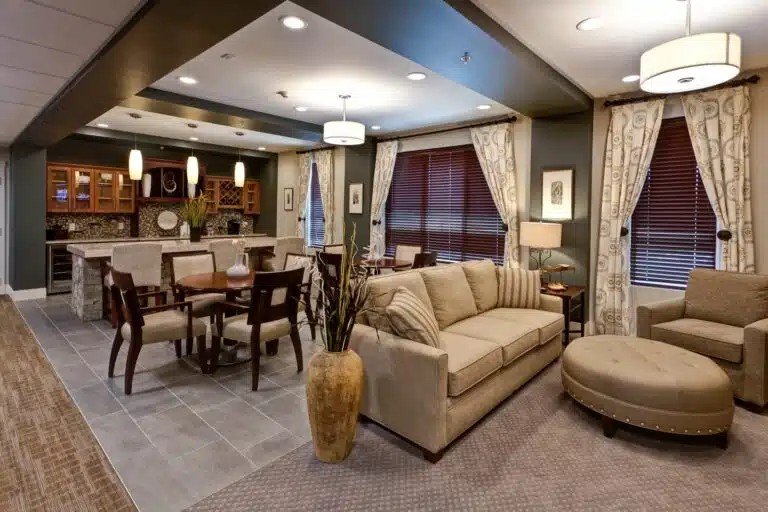 A living room with a grey carpet and a beige sofa  at The Piper, Kansas City, KS.
